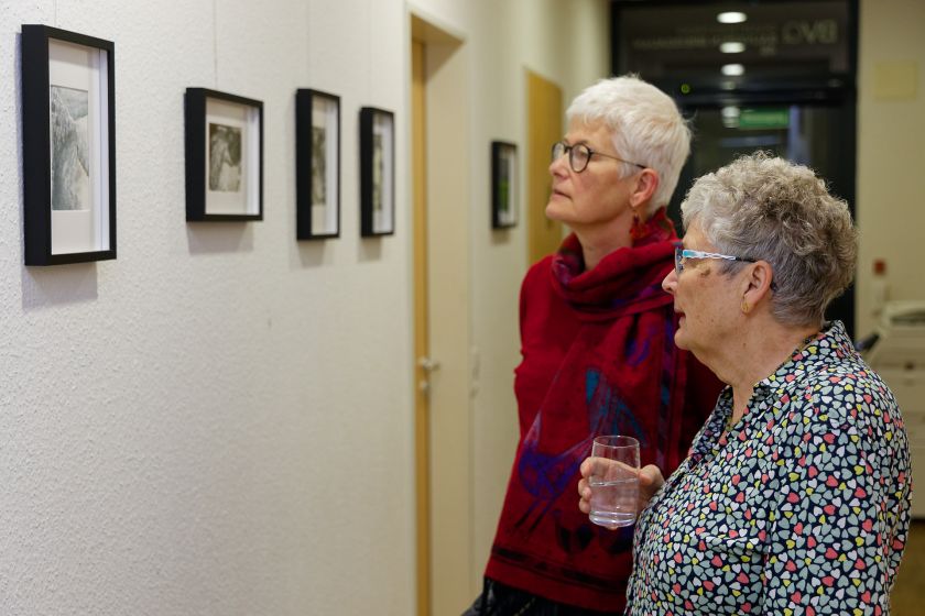 Zwei Frauen betrachten Bilder an der Wand